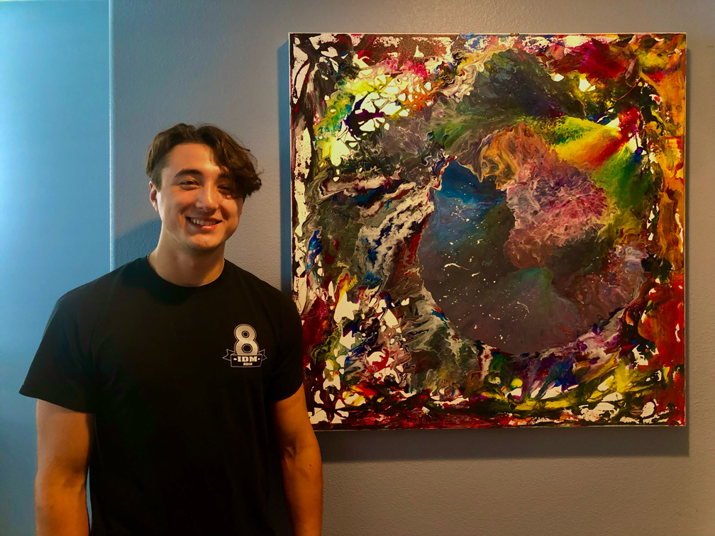 Damien beside Donna Cali's Beyond the Universe painting