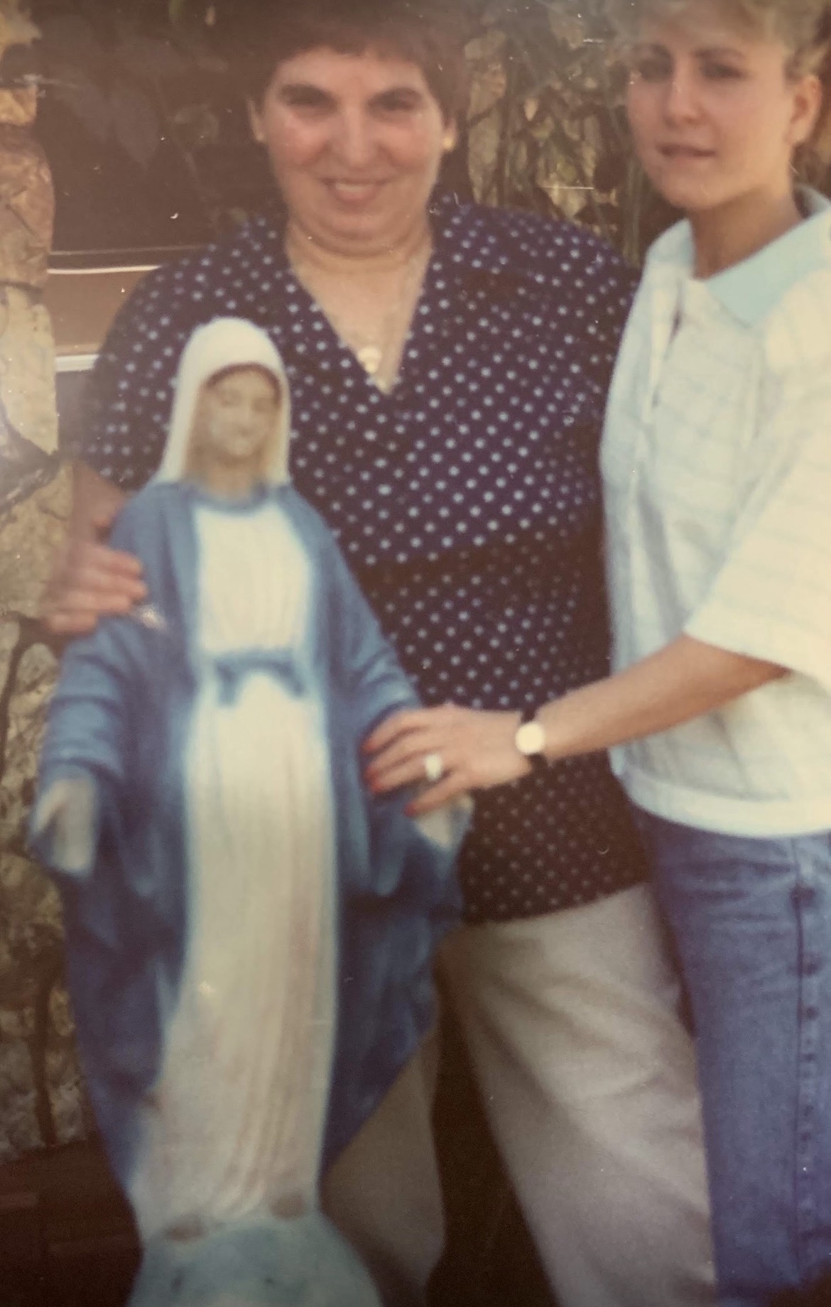 A photo of me and my aunt at my backyard with a Virgin Mary statue